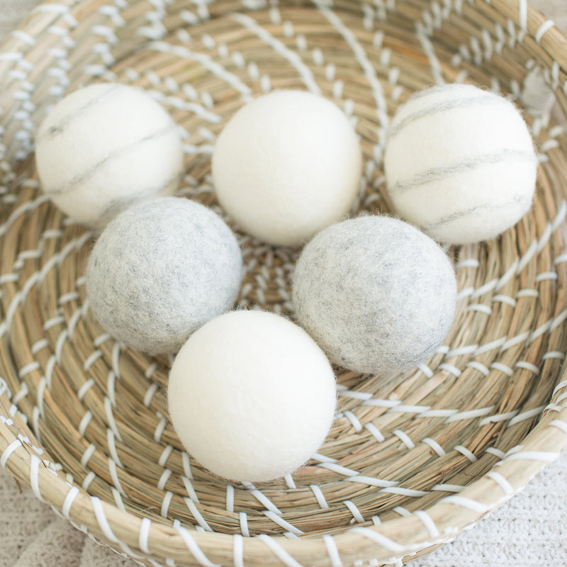 six wool dryer balls, two white, 2 gray, and two marbled