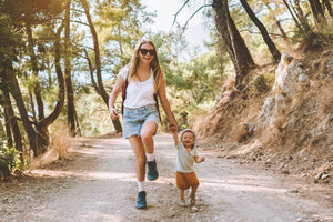 Young mom and little son hiking and smiling