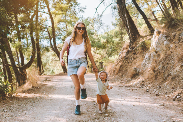 Young mom and little son hiking and smiling