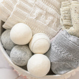 wool dryer balls in a laundry basket with clean clothes