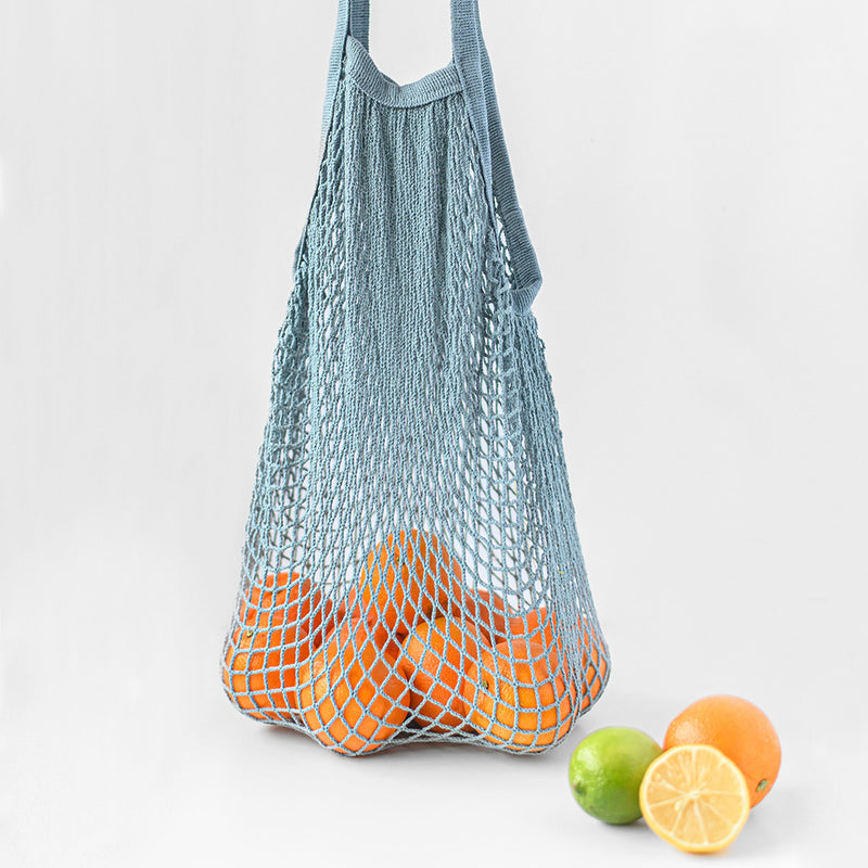 100% cotton blue reusable bag for vegetables and fruits with oranges.