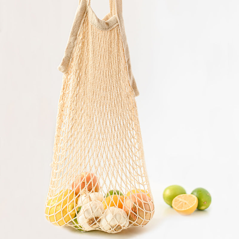 100% natural and reusable grocery bag with garlic, limes and lemons.