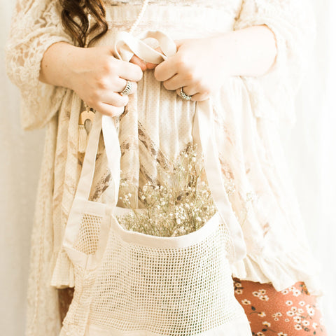 Woman holding a reusable shopping bag for groceries.